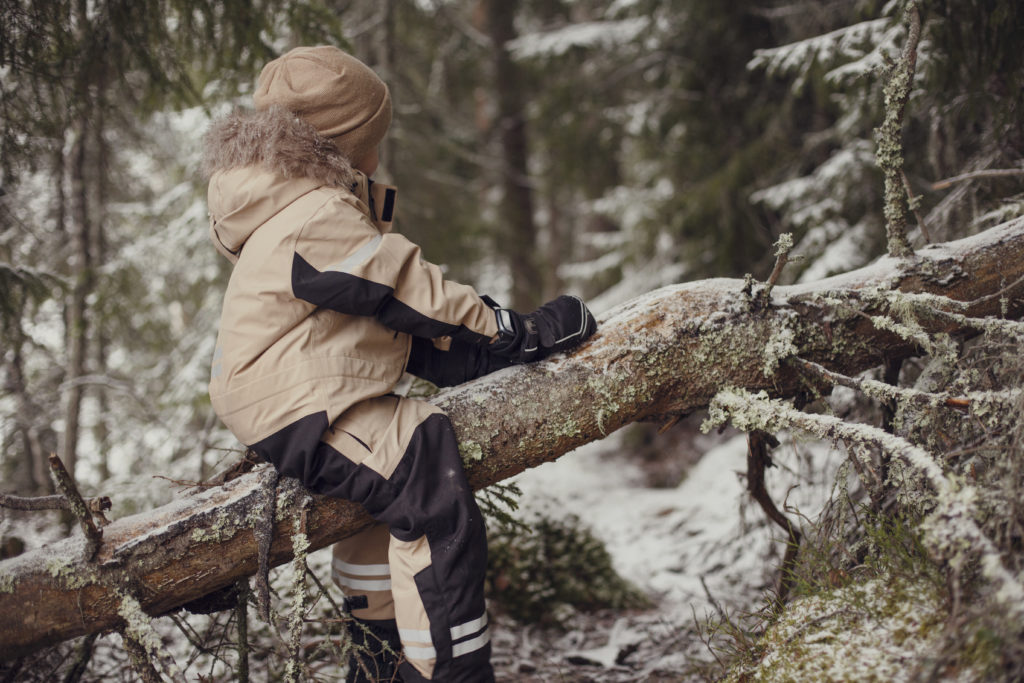 Lapsi leikkii metsässä
