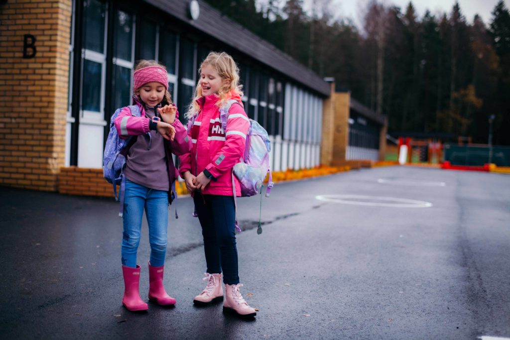 Xplora lapsen ranteessa koulunpihalla. Puhelin koulusssa.