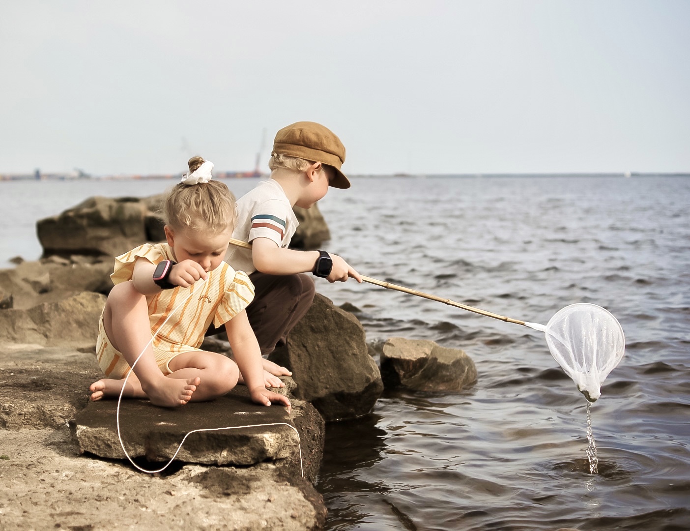 Lapset kalassa Lasten kellopuhelin ranteessa.